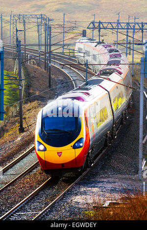 Stromleitungen, und Galgen für elektrische, Züge, Titel & Passagiere auf British Railways Absteigend Virgin Voyager am Bahnhof Shap, West Coast L Stockfoto