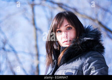 Porträt von einer hübschen Frau posiert im Wald im winter Stockfoto