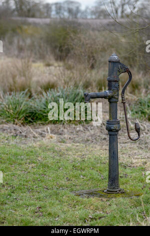 Alte handbetriebene, hin-und hergehenden, positive Verschiebung, gusseiserne gusseiserne Wasserpumpe in einem Yorkshire-Feld. Stockfoto