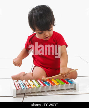 Kleiner Junge (16 Monate) sitzen spielen bunte Xylophon Stockfoto