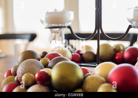 Eine Tabelle für eine Feier Mahlzeit gelegt. Weihnachtsschmuck, Dekorationen und eine Kerze in einen Kerzenständer. Stockfoto