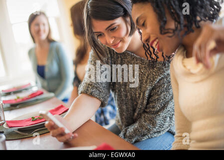 Zwei Frauen, die an einem Handy-Bildschirm. Stockfoto