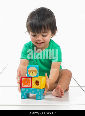 Baby Junge (16 Monate) sitzt mit Bausteinen zu spielen Stockfoto