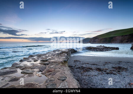 Wellen Waschen über der alten Hafenmauer in Portwrinkle an der südlichen Küste von Cornwall Stockfoto