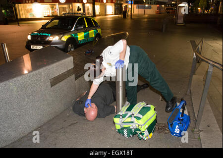 Sanitäter Krisenreaktions-Behandlung von ein Mann, der gefunden wurde stürzte von einem Mitglied der Öffentlichkeit in Birmingham Stadtzentrum entfernt. Stockfoto