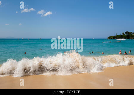 Urlauber und Einheimische schwimmen im Atlantik Wellen in Holiday Resort von Sosua, Dominikanische Republik, Karibik Inseln Stockfoto