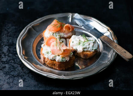 Kanapees mit geräuchertem Lachs und Frischkäse zu verbreiten, auf Vintage Metallplatte, selektiven Fokus Stockfoto