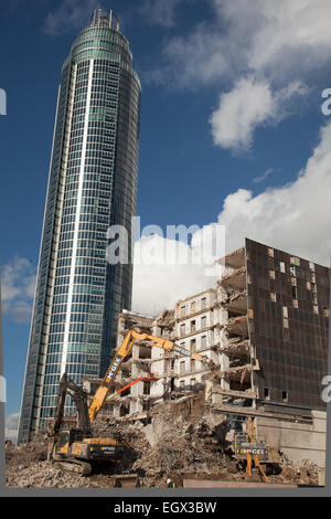 Abriss und Neubau mit mechanischen Digger im Vordergrund Stockfoto