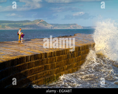 Menschen stehen auf The Cobb am Hafen in Lyme Regis Dorset England UK einen künstlichen Struktur ursprünglich aus 1313 Stockfoto