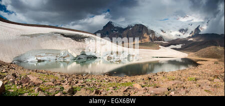 Bergsee auf dem Gletscher im Hintergrund des Kaukasus und Mount Elbrus Stockfoto