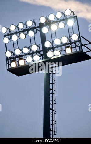 Fußball-Stadion-Scheinwerfer eingeschaltet bei Sonnenuntergang Stockfoto