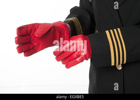 Vier goldene Ringe auf Airline Offiziere einheitliche Putting auf rote Handschuhe Stockfoto