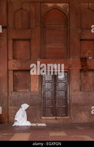 Indische Frau beten auf ihr eigenes in Fatehpur Sikri, Uttar Pradesh, Indien Stockfoto