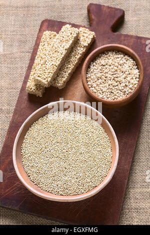 Overhead Schuss von rohen weißen Quinoa (Chenopodium Quinoa lat.) Getreide Samen in Schüssel mit geplatzten Quinoa Getreide und Quinoa Müsliriegel Stockfoto