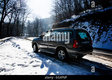 Linke Seite des Mazda Tribute Sport Utiliy Fahrzeugs auf der Bergstrasse im winter Stockfoto