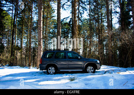 Rechten Fahrzeugseite Mazda Tribute Sport Utiliy im Bergwald im Winterschnee Stockfoto