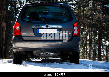 Nahaufnahme der Rückseite des Mazda Tribute Sport Utiliy Fahrzeug im Bergwald im Winterschnee Stockfoto