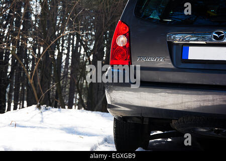 Nahaufnahme der Rückseite des Mazda Tribute Sport Utiliy Fahrzeug im Bergwald im Winterschnee Stockfoto