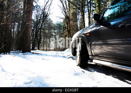 Linke Seite des Mazda Tribute Sport Utiliy Fahrzeugs auf der Bergstrasse im winter Stockfoto