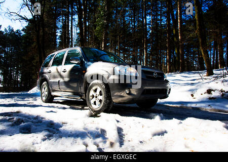 Rechten vorderen Seite des Mazda Tribute Sport Utiliy Fahrzeug auf der Bergstrasse im Schnee Stockfoto