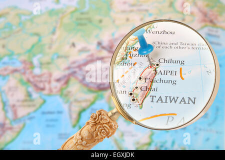 Blauen Stift auf der Weltkarte mit Lupe suchen in Taipei, Taiwan Stockfoto