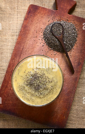 Overhead Schuss von Mango Pudding mit Chia-Samen (lat. Salvia Hispanica) auf Holzbrett mit Tageslicht fotografiert Stockfoto