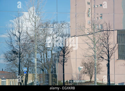 VALLINGBY, STOCKHOLM, Schweden - 18. April 2014: Abstrakte Architektur. Gebäude und Bäume spiegeln sich in modernen Glasfassade auf Ap Stockfoto