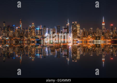 Lower Manhattan Skyline bei Nacht spiegelt sich im Wasser Stockfoto