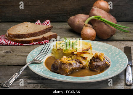 Walisische Essen - geschmortes Schweinefleisch Wangen in Sauce mit karamellisierten Lauch-Zwiebel-Kuchen Stockfoto