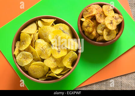 Overhead Schuss von salzig (links) und süß (rechts) Wegerich-chips in Schalen, ein beliebter Snack in Südamerika Stockfoto