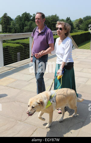 Frau mit Sehbehinderungen mit Helfer und Blindenhund auf Gelände des Yorkshire Sculpture Park. Stockfoto