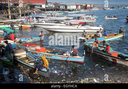 Hölzerne Taxiboote warten für die Passagiere auf der Uferpromenade, übersät mit Kunststoff-Flaschen und anderen Müll in Semporna, Borneo Stockfoto