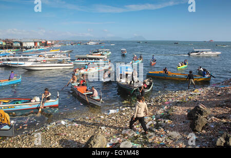 Hölzerne Taxiboote warten für die Passagiere auf der Uferpromenade, übersät mit Kunststoff-Flaschen und anderen Müll in Semporna, Borneo Stockfoto