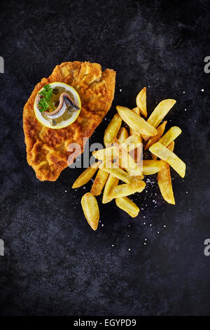 Schnitzel und Pommes Frites auf dunklen Grund Stockfoto