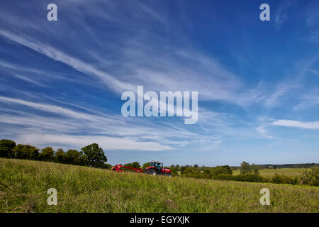 Traktor und Mähwerk arbeiten in der englischen Landschaft Stockfoto