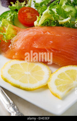 Selektiven Fokus auf frischem Lachs auf einem weißen Teller mit Salat Stockfoto