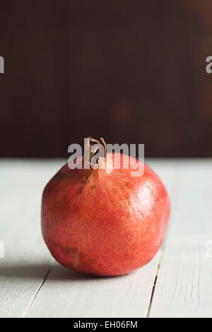 Still-Leben essen Bild von einen einzigen Granatapfel auf einem Holztisch Stockfoto