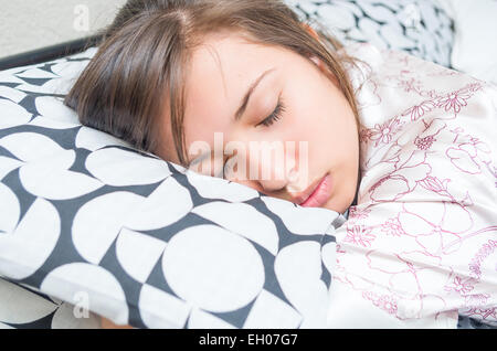 süße junge Mädchen umarmt Kissen schlafen Stockfoto
