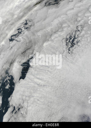 Höhen-Flugzeug hinterlässt Kondensstreifen oder Kondensstreifen, die entstehen, wenn sich zusätzliche Wasserdampf in der Atmosphäre durch das Flugzeug Auspuff eingespritzt wird. Am 9. Februar 2015 eroberte die Moderate Resolution Imaging Spektroradiometer (MODIS) auf NASA Satelliten Terra dieses Bild von Kondensstreifen über Wolken über den Nordatlantik. Stockfoto