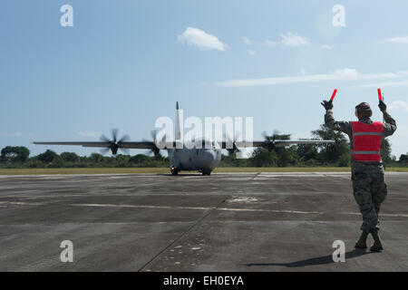 Ein US Air Force Flieger aus der 36. Kontingenz Reaktionsgruppe Marschälle einen Royal Australian Air Force c-130 Hercules in Position, während eine humanitäre Hilfe und Katastrophenschutz Relief Fortbildungsveranstaltung in Rota, Nördliche Marianen, 15. Februar 2015 Fracht auszuladen. Übung Cope North 15 erhöht humanitäre Hilfe und Disaster Relief Krise Reaktionsmöglichkeiten zwischen den sechs Nationen und legt den Grundstein für die regionale Zusammenarbeit Expansion während der realen Risiken in der Region Asien-Pazifik. Stockfoto