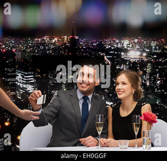 lächelnde paar zum Abendessen mit Kreditkarte bezahlen Stockfoto