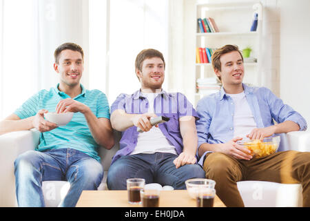 glücklich männlichen Freunden vor dem Fernseher zu Hause Stockfoto