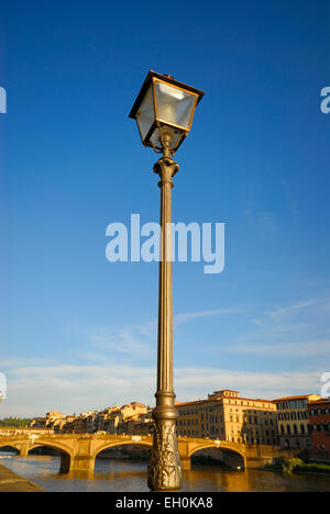 Alte verzierte Laterne am Lungarno Degli Acciaiuoli Straße neben Arno Fluss (Ponte Santa Trinita-Brücke), Florenz, Italien Stockfoto