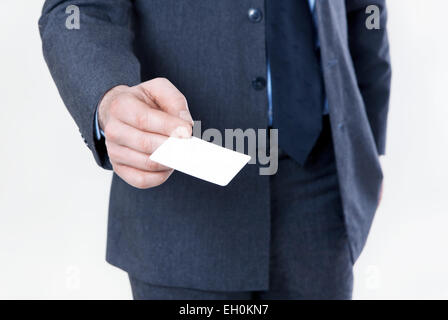 Mann im Anzug mit Krawatte hält eine weiße Visitenkarte in der Hand, kein Gesicht Stockfoto