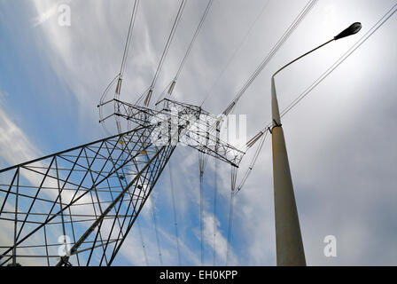 Hochspannung Netzteil Linien und Stahlpylone neben Straßenlaterne Stockfoto