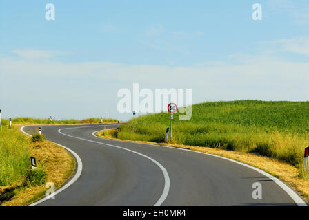 Kurvenreiche Landstraße durch Landschaft mit Tempolimit Schild, Toskana, Italien Stockfoto