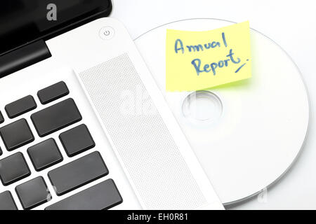 Weiße Notebook mit jährlichen Geschäftsbericht dvd-Datenträger in Slot-in-Laufwerk auf einem weißen Hintergrund. Stockfoto