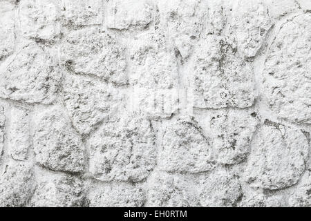 Alte weiße gemalte Wand aus runden Steinen, Foto Hintergrundtextur Stockfoto