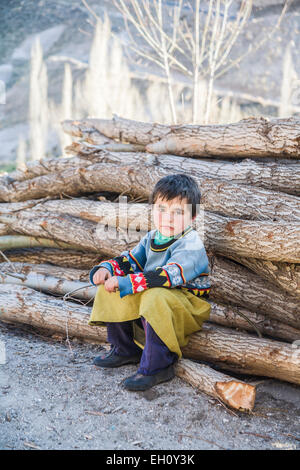 Süße Junge türkische Mädchen im lokalen Stil Kleidung auf einem Haufen von Logs schauen nachdenklich oder traurig in Göreme, Kappadokien, Türkei gekleidet sitzen Stockfoto