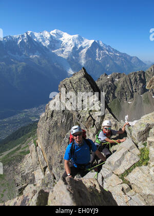 Junge und Vater Klettern an einem sonnigen Tag in den Alpen.  Mont Blanc ist im Hintergrund. Stockfoto